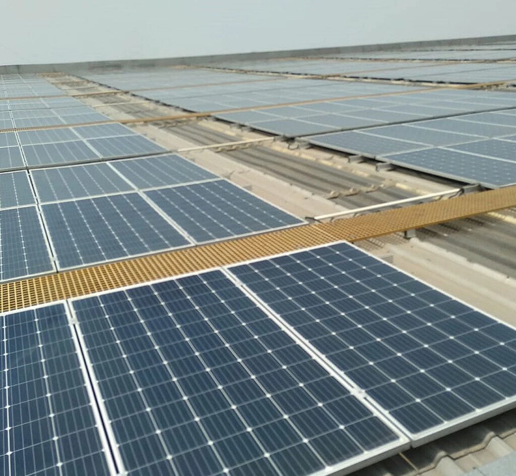 Close-up of workers installing solar panels on a building.