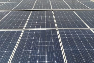 Solar Panel Solutions (3) Technicians maintaining and cleaning industrial solar panels on a large rooftop
